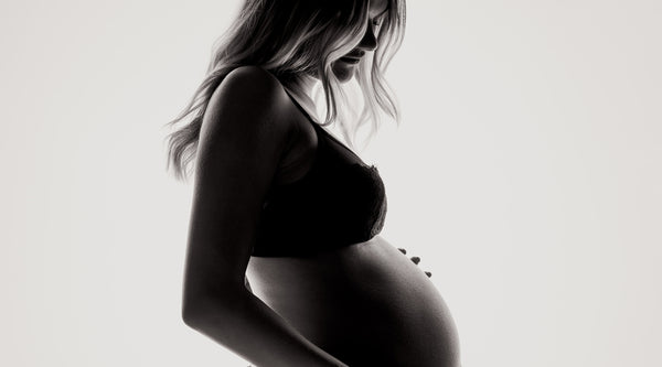 Photo de profil d'une femme enceinte en sous-vêtements. ©Janko Ferlic pour Unsplash.